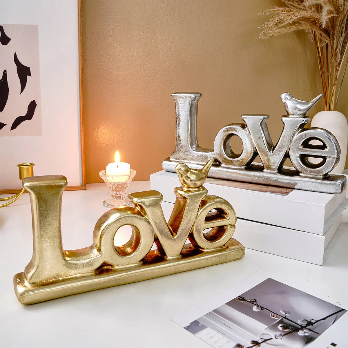 Retro gold and silver foil resin letters spelling LOVE displayed on a white surface.