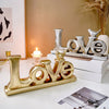 Retro gold and silver foil resin letters spelling LOVE displayed on a white surface.