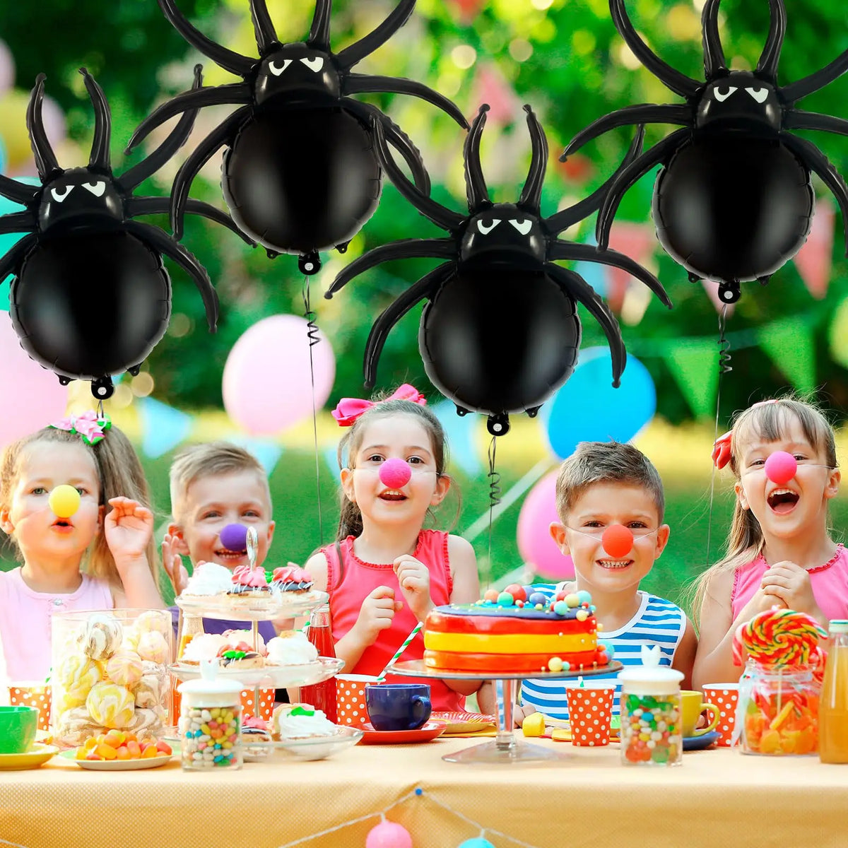 Tischdarstellung mit sechs schwarzen Spinnenballon-Foilballons und bunten Leckereien für eine Party.