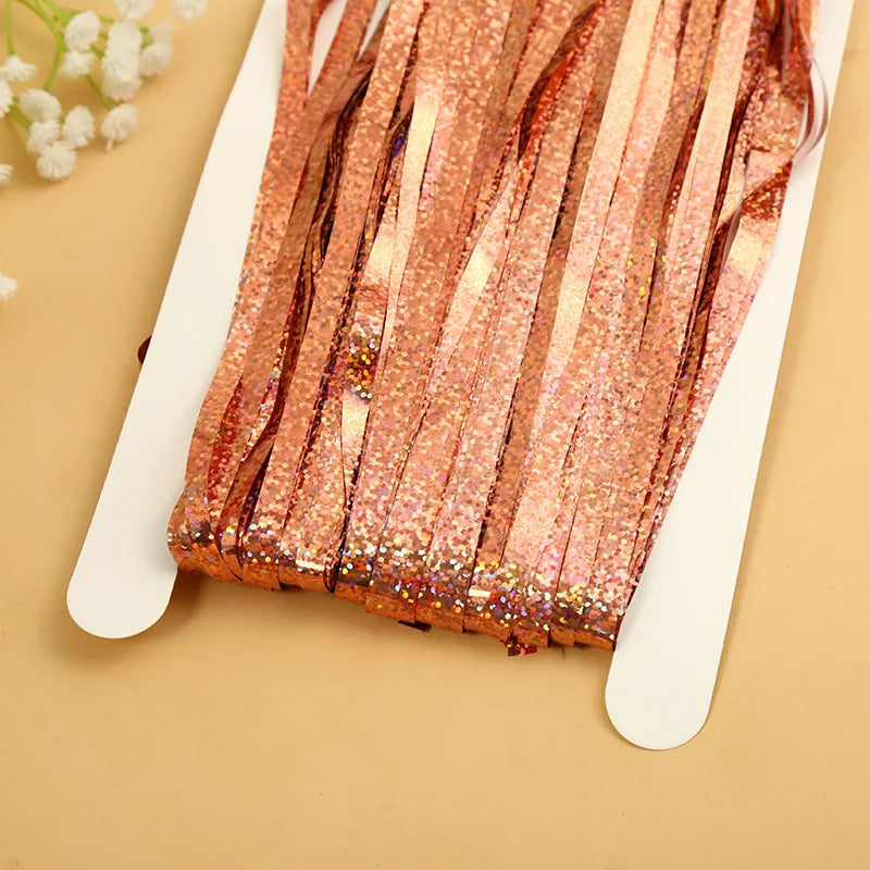 Pink metallic tinsel foil fringe curtain backdrop with glitter texture displayed on a white card.