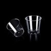 A clear glass shot glass is shown against a black background.