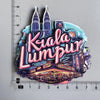 A collection of wooden destination fridge magnets featuring Kuala Lumpur landmarks and text.