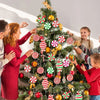 A family is decorating a Christmas tree with rustic wooden peppermint candy ornaments.