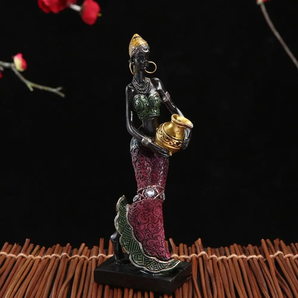Hand-painted resin statue of an African tribal lady with gold jewelry and patterned clothing.