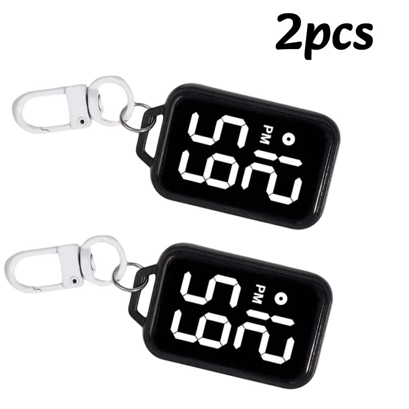 Two black LED keychain pocket watches with digital displays and silver clasps