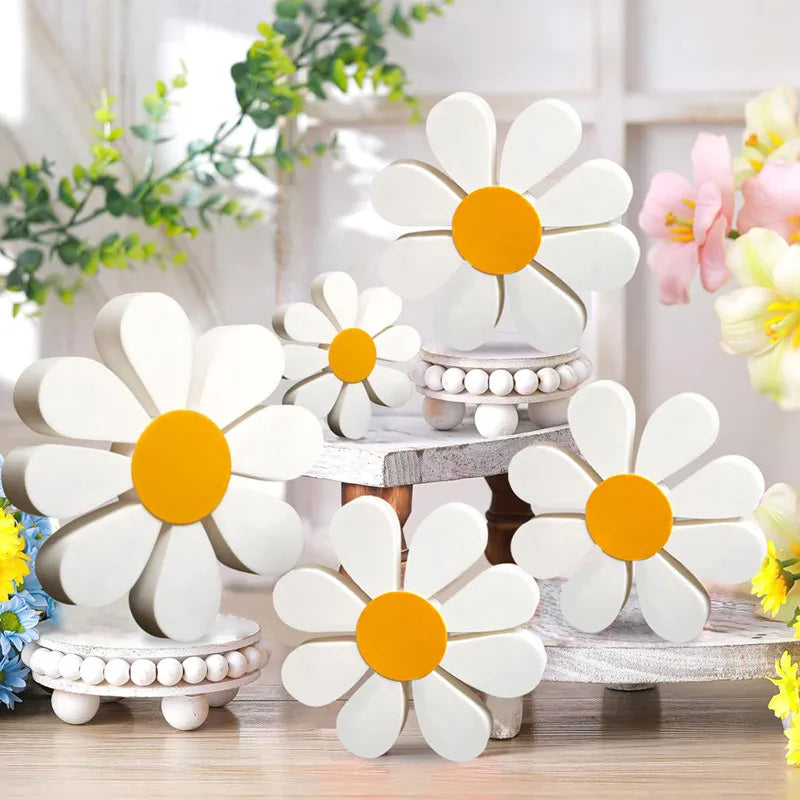 Set of three white and orange wooden daisy flower ornaments displayed on a light wooden surface.