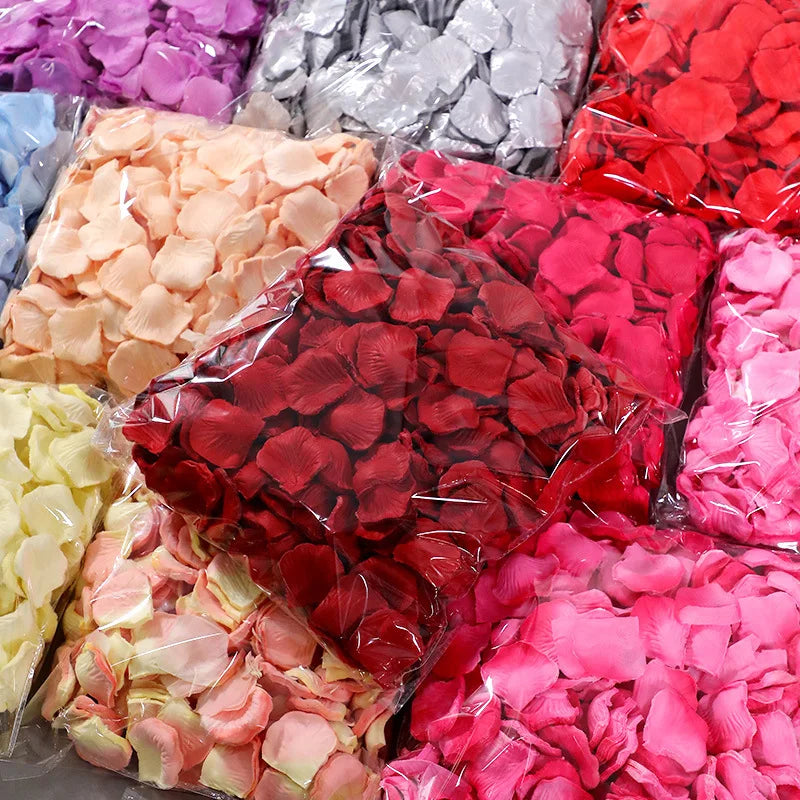 A variety of pink and red silk rose petals in various shades are displayed in clear plastic bags.