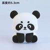 A white and black panda-shaped decoration with large eyes and ears.