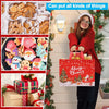 A woman holds a red knitted sweater and a festive gift bag with a Christmas theme.
