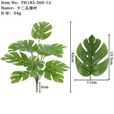 Artificial tropical plant decor showing a green leafy plant with large, lobed leaves.