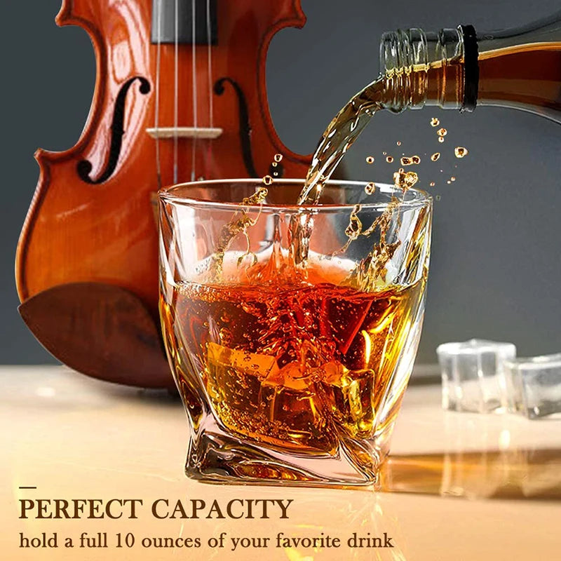 A glass of amber whiskey is being poured into a heavy base tumbler next to a wooden violin.