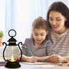 A woman is drawing with a child at a desk using a retro battery-powered desk lamp.