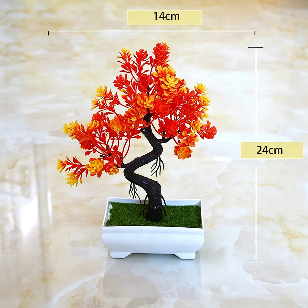 An artificial bonsai tree decoration with vibrant orange and yellow foliage planted in a white rectangular pot.