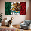 A decorative banner featuring the Mexican flag design with a golden eagle and intricate patterns hanging on a wall.