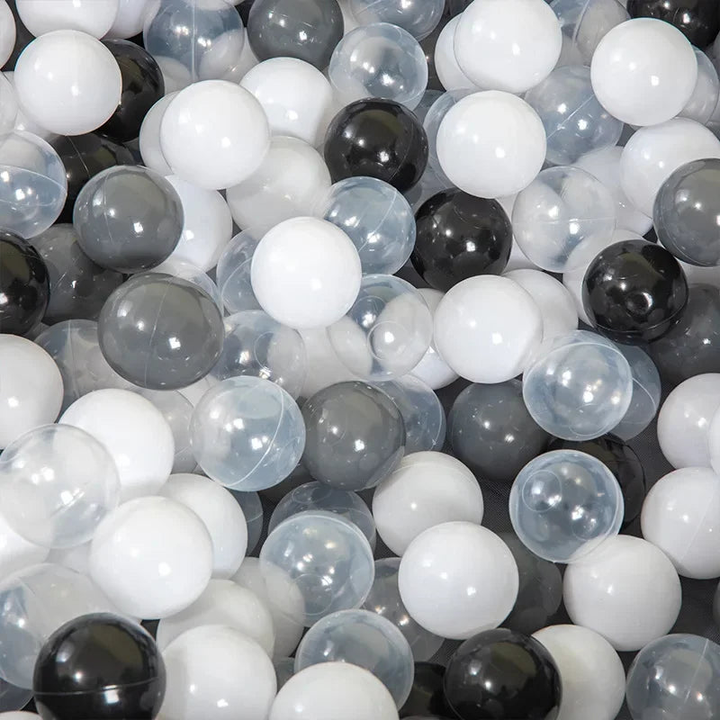 A collection of clear and opaque white, gray, and black plastic balls for play areas.