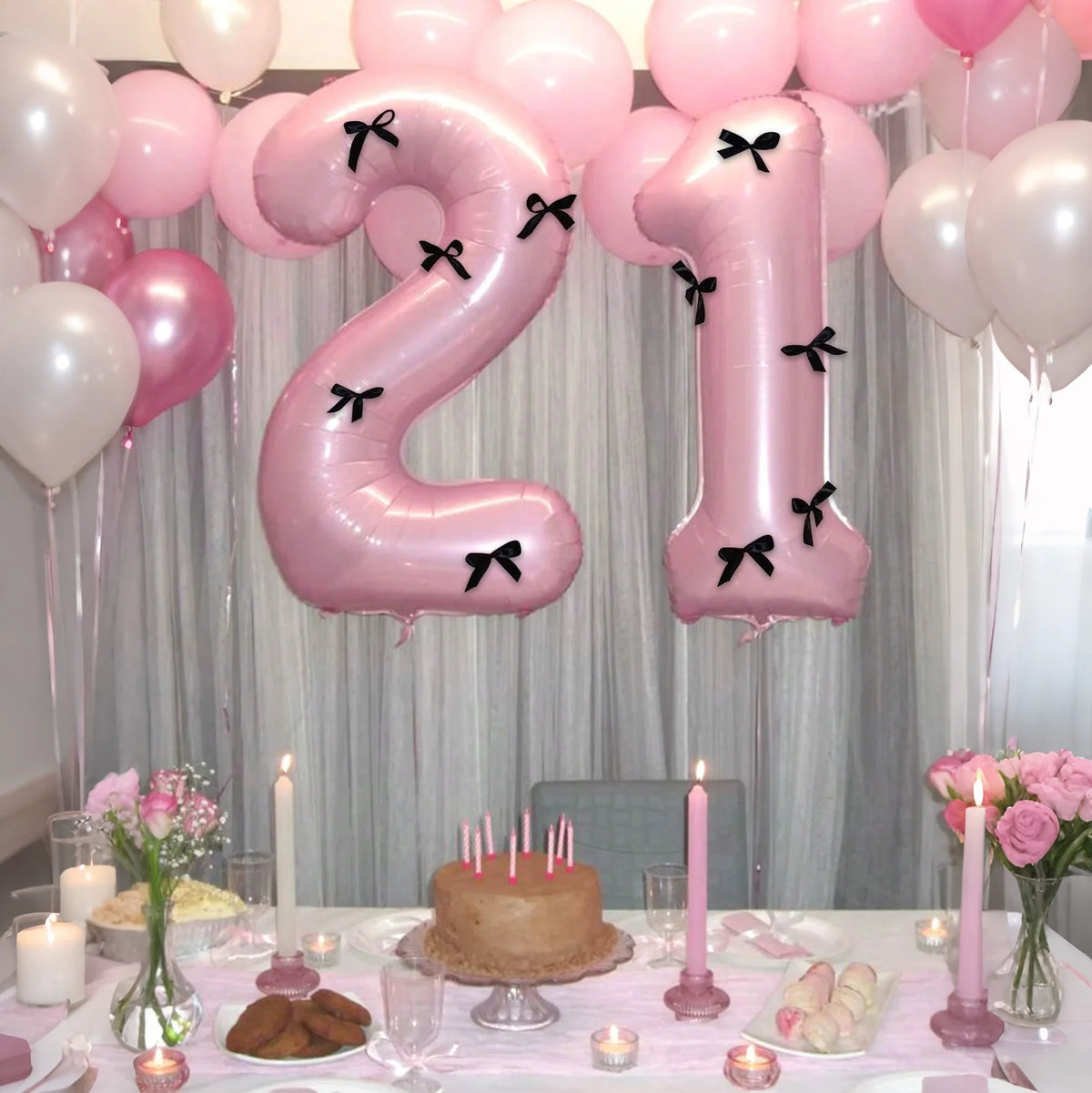 A large pink number balloon set featuring the number 1 with black bows, displayed in a soft light setting.
