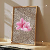Framed canvas wall art featuring a pink leopard print background with a central hibiscus flower.
