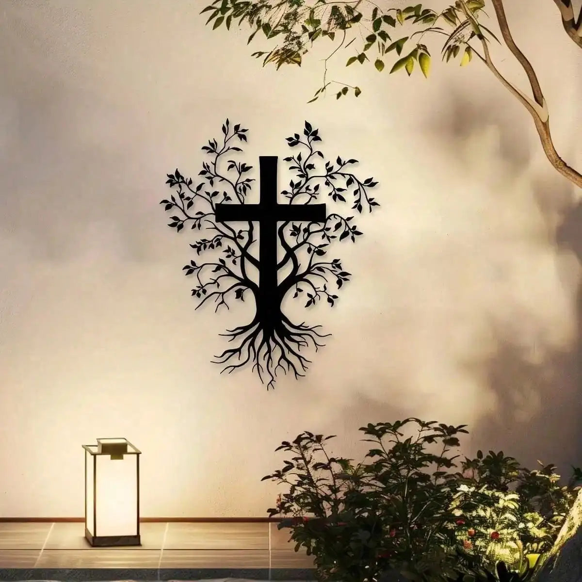 A black iron branch cross wall decor silhouette against a light wall with foliage and a wooden floor.