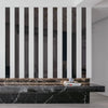 A modern interior featuring a wall with vertical black and white stripes, above a dark marble countertop.