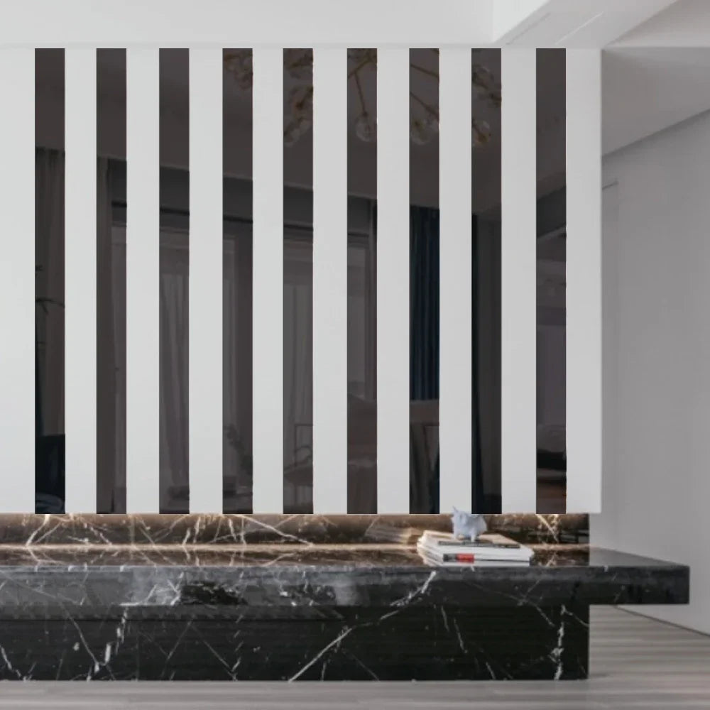 A modern interior featuring a wall with vertical black and white stripes, above a dark marble countertop.