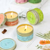 A collection of natural soy wax travel candles in various colors, including orange, green, and blue, set against a white back