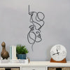 Black line art wall art depicting a minimalist abstract profile of a face on a gray wall.