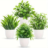 A set of four small artificial bonsai plants in various shades of green potted in white containers.