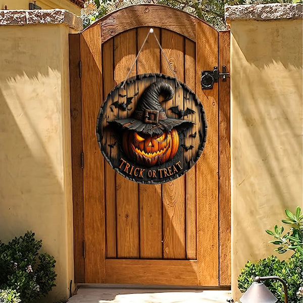 A round wooden Halloween decoration sign featuring a carved pumpkin face hanging on a rustic wooden door.