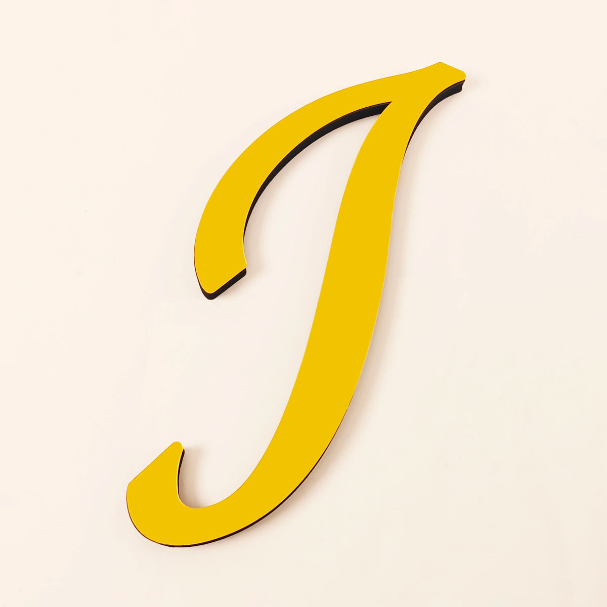 A yellow 3D acrylic letter J wall sticker against a light background.
