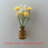 A small glass vase holds a random yellow flower arrangement for fridge decor.