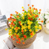 A potted artificial eucalyptus branch with bright orange and yellow faux flowers for home decor.