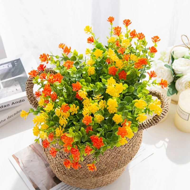 A potted artificial eucalyptus branch with bright orange and yellow faux flowers for home decor.