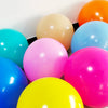 A collection of brightly colored matte latex balloons including yellow, pink, blue, and orange.