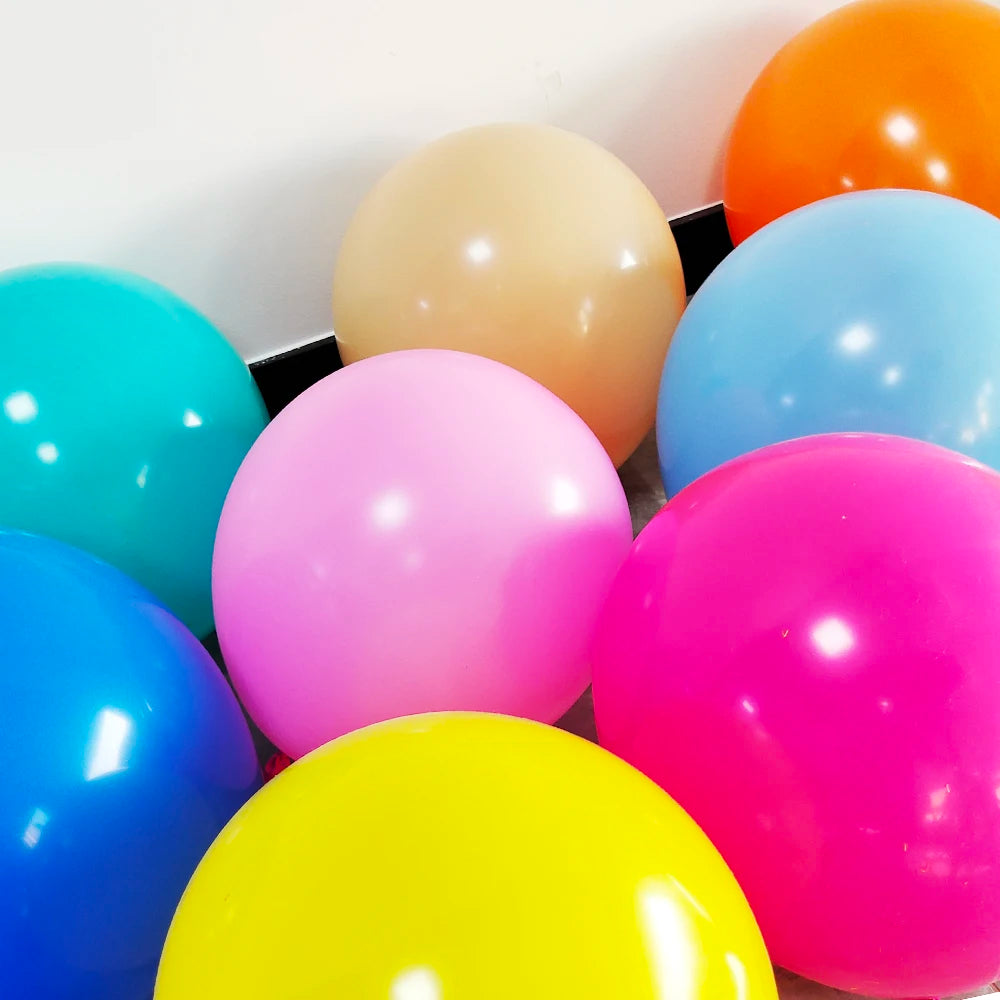 A collection of brightly colored matte latex balloons including yellow, pink, blue, and orange.