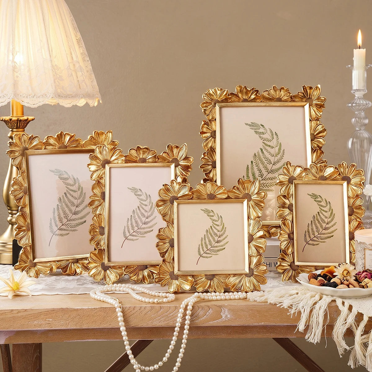 A collection of golden 3D resin photo frames with floral accents displayed on a wooden table.