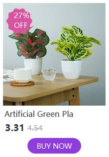 Plante verte artificielle dans un pot blanc, exposée sur une surface en bois avec une étiquette de réduction.
