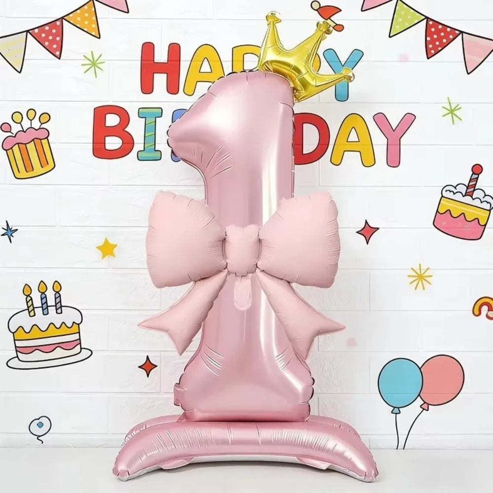 A large pink foil balloon shaped like the number one with a crown detail, used for a birthday celebration.