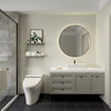 A modern bathroom featuring a white vanity, circular mirror, and toilet against a light wall with dark floor tiles.