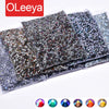 A collection of hotfix glass rhinestones in various sizes and colors, including iridescent and clear crystals.