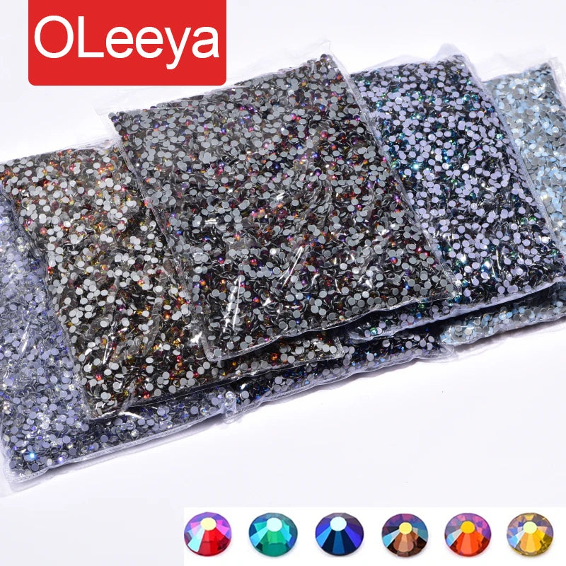 A collection of hotfix glass rhinestones in various sizes and colors, including iridescent and clear crystals.