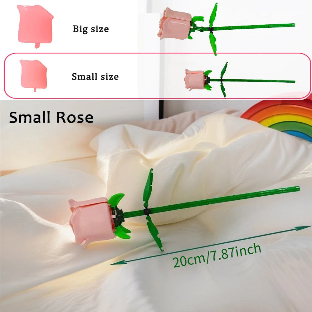 A small pink rose flower building block with a green stem is shown against white fabric.