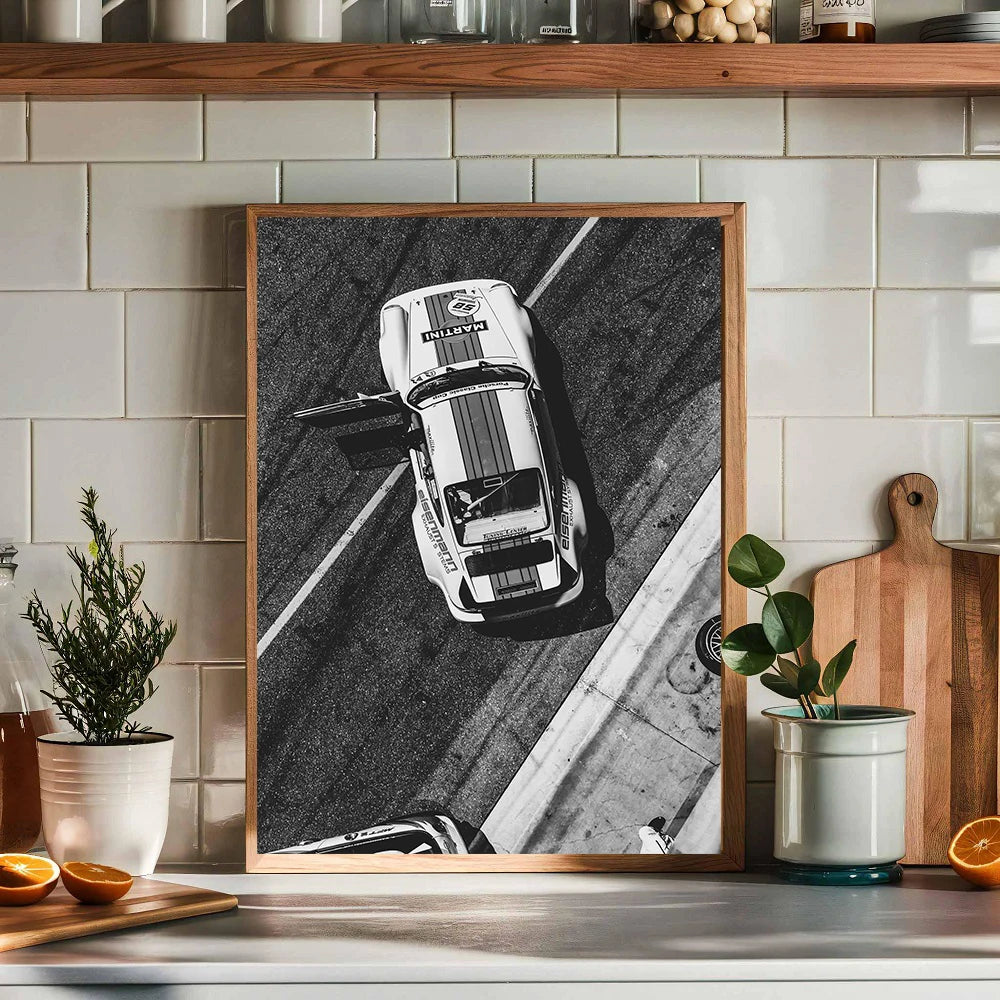 Impression d'art encadrée en noir et blanc d'une voiture moderne vue de face, exposée sur un comptoir de cuisine.