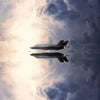 A military jet aircraft silhouetted against a bright lightning flash and dark storm clouds.