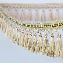 Golden beige tassel fringe trim used for decorative edging on curtains and DIY projects