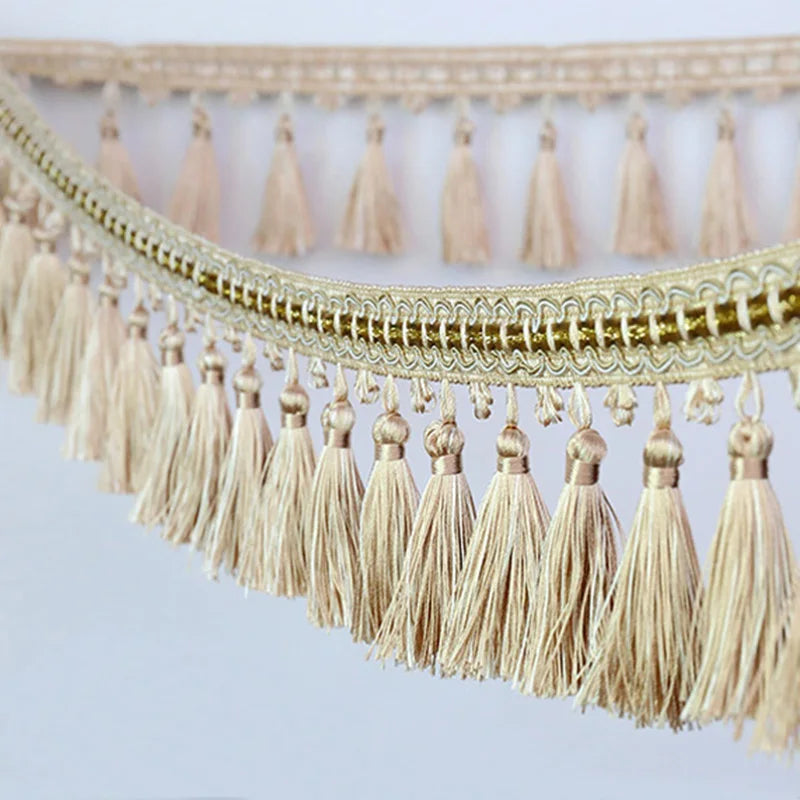 Golden beige tassel fringe trim used for decorative edging on curtains and DIY projects