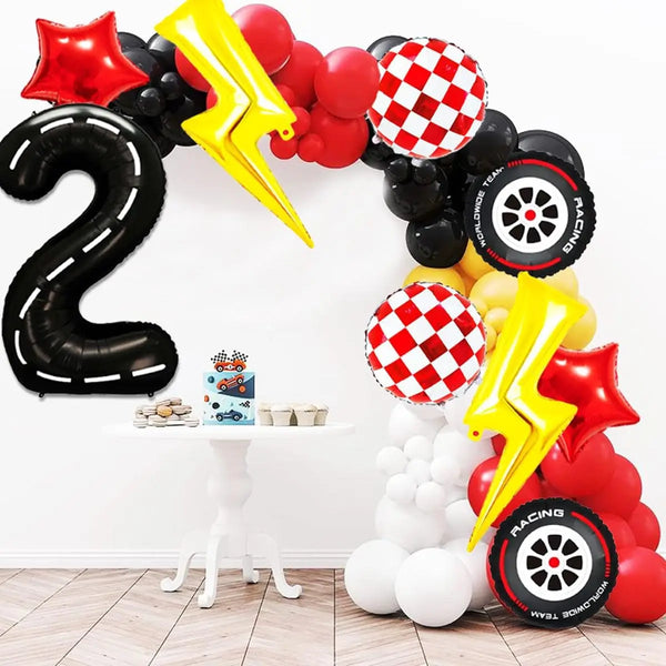A large black foil number 2 arch decorated with red and yellow balloons for a birthday party.