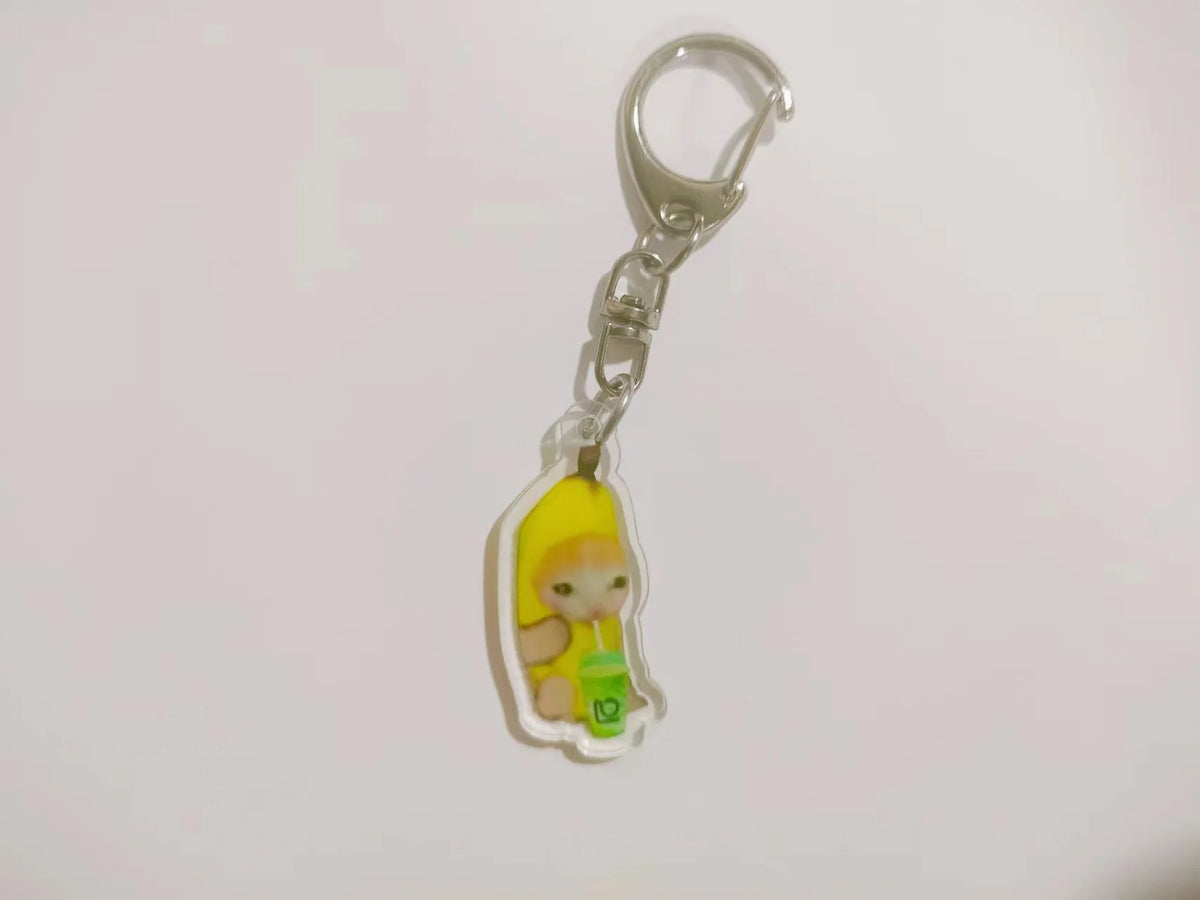 Acrylic keychain featuring a yellow banana cat character holding a green drink.