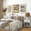 A bedroom featuring a bed with neutral bedding and three framed scripture art pieces on the wall.