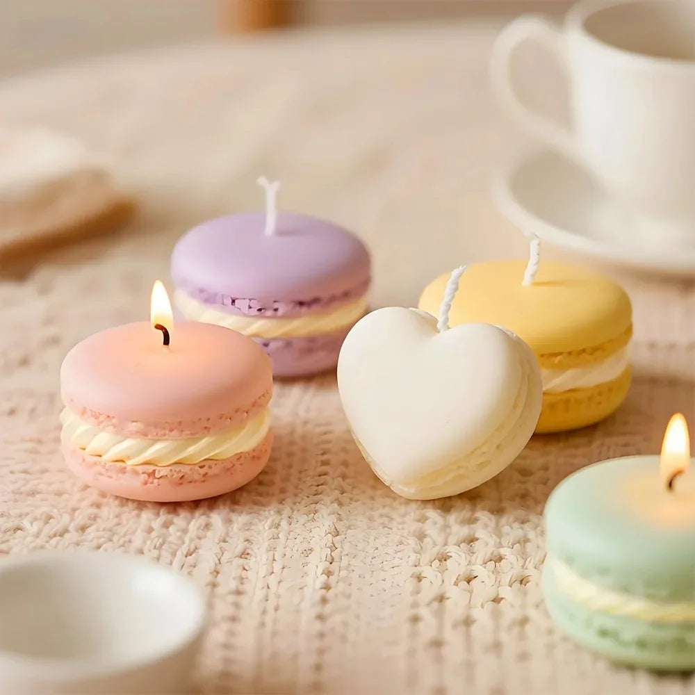 A collection of pastel-colored macaron-shaped soy wax candles arranged on a light fabric surface.