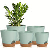 A set of five light green self-watering plant pots with drainage holes, shown in various sizes.